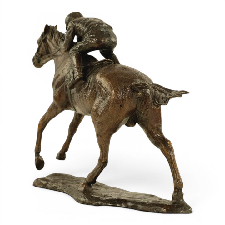 Escultura de bronce de un jinete sobre un caballo de carreras