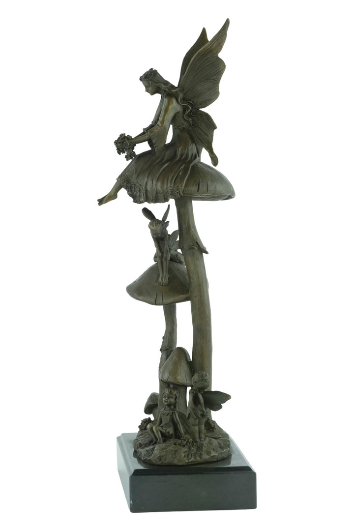Bronze sculpture of a group of fairies sitting on mushrooms