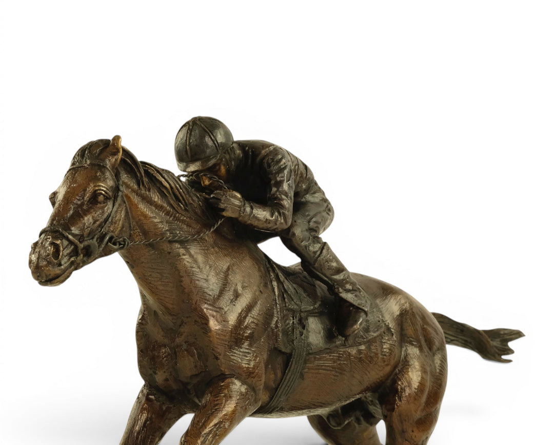 Escultura de bronce de un jinete sobre un caballo de carreras
