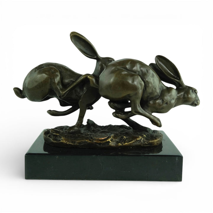 Escultura de bronce de dos liebres corriendo