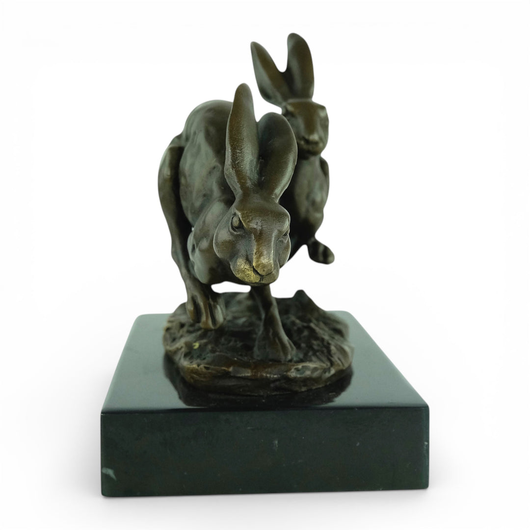 Escultura de bronce de dos liebres corriendo
