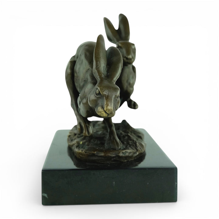 Escultura de bronce de dos liebres corriendo