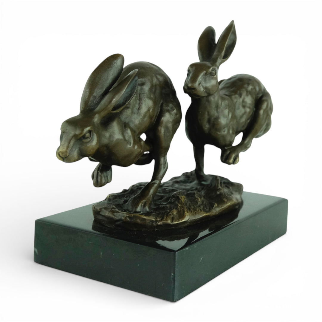 Escultura de bronce de dos liebres corriendo