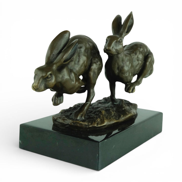 Escultura de bronce de dos liebres corriendo