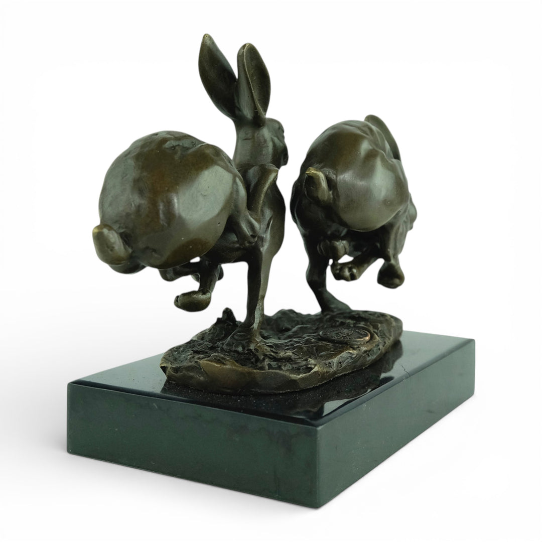 Escultura de bronce de dos liebres corriendo