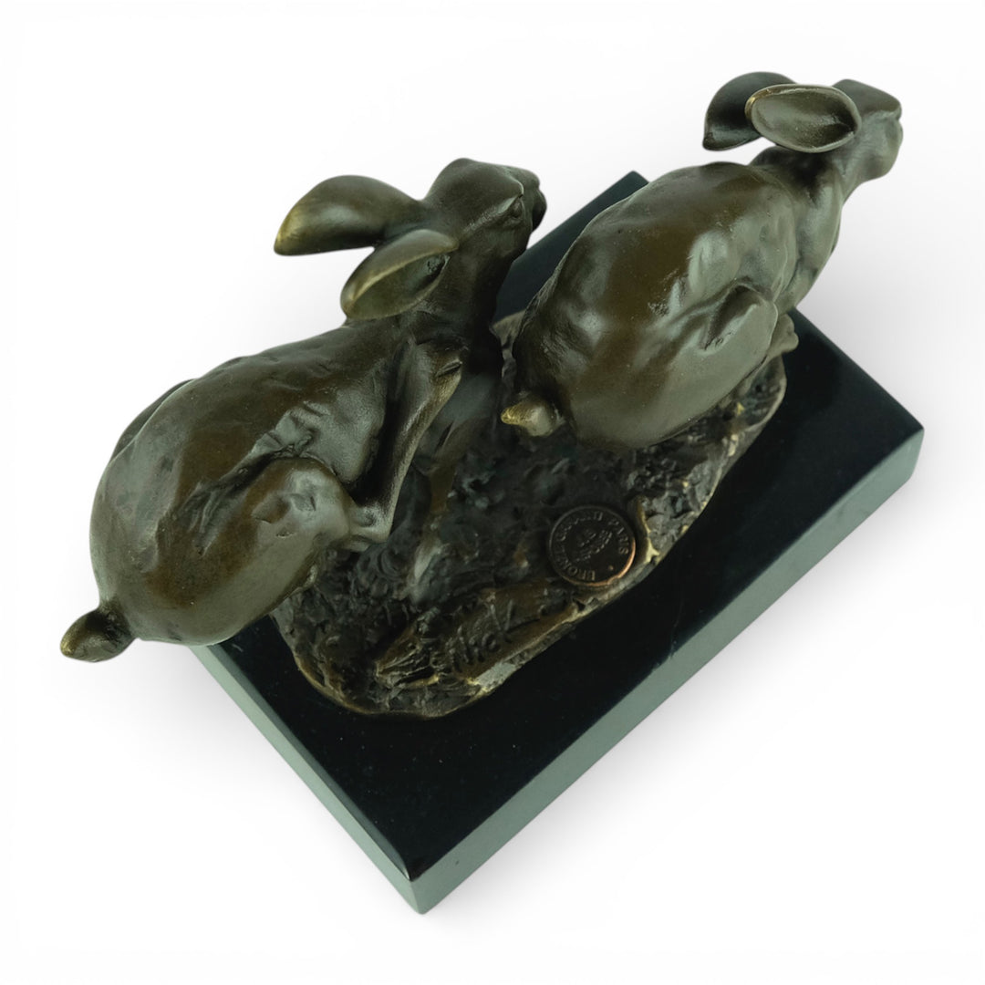 Escultura de bronce de dos liebres corriendo
