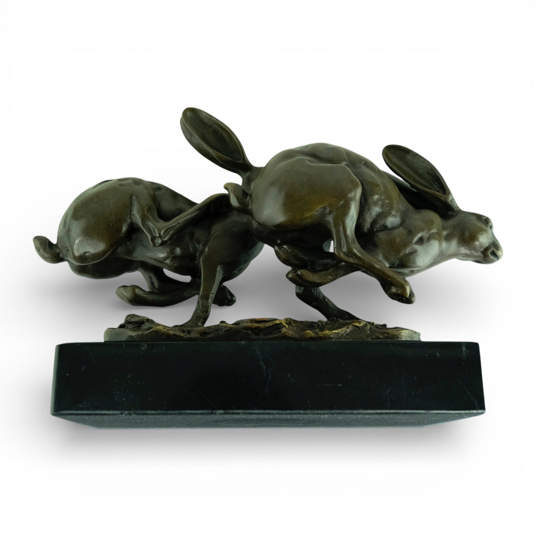 Escultura de bronce de dos liebres corriendo