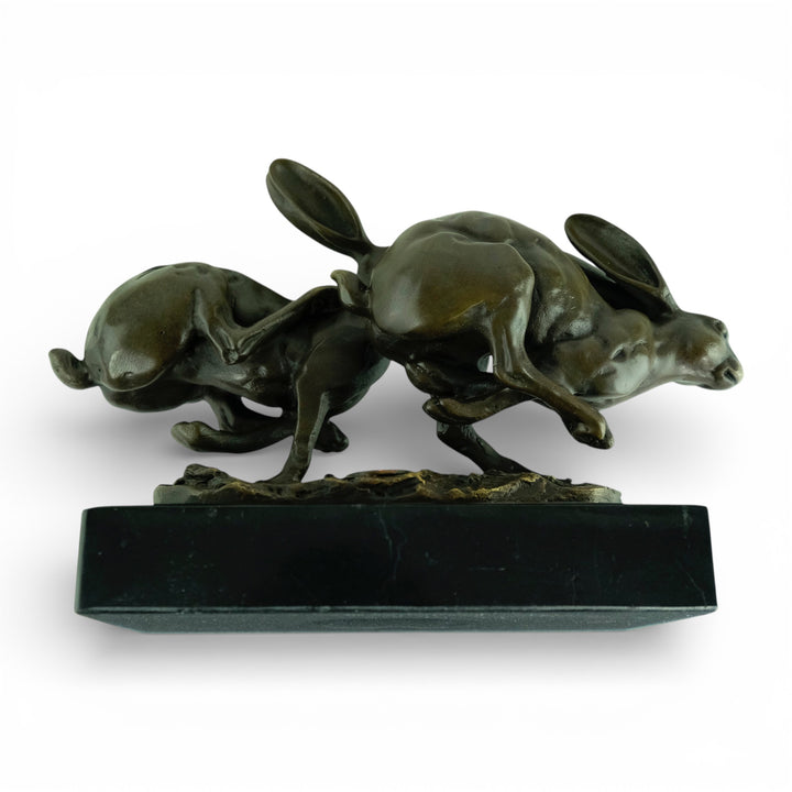 Escultura de bronce de dos liebres corriendo