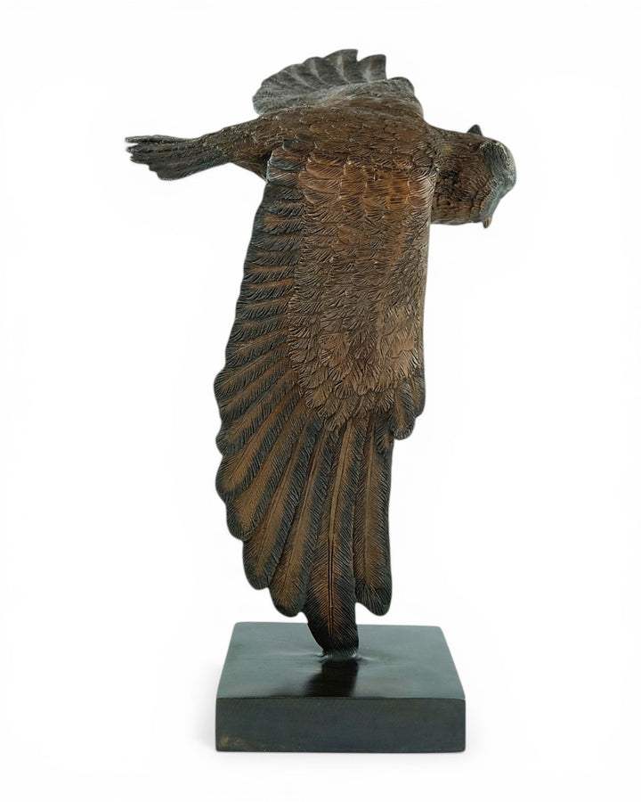 Bronzen beeld van een uil in dalende vlucht