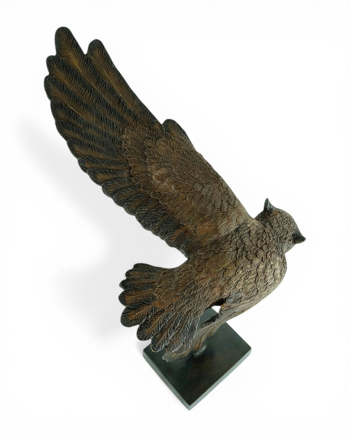 Bronzen beeld van een uil in dalende vlucht