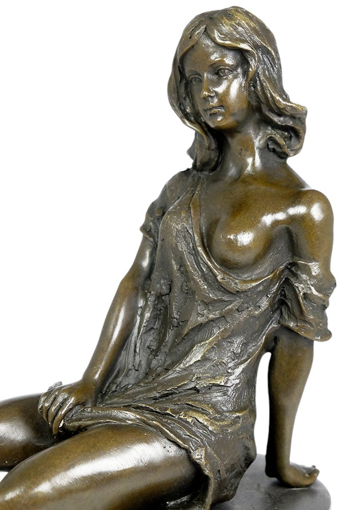Bronze sculpture of a sitting female in flimsy dress