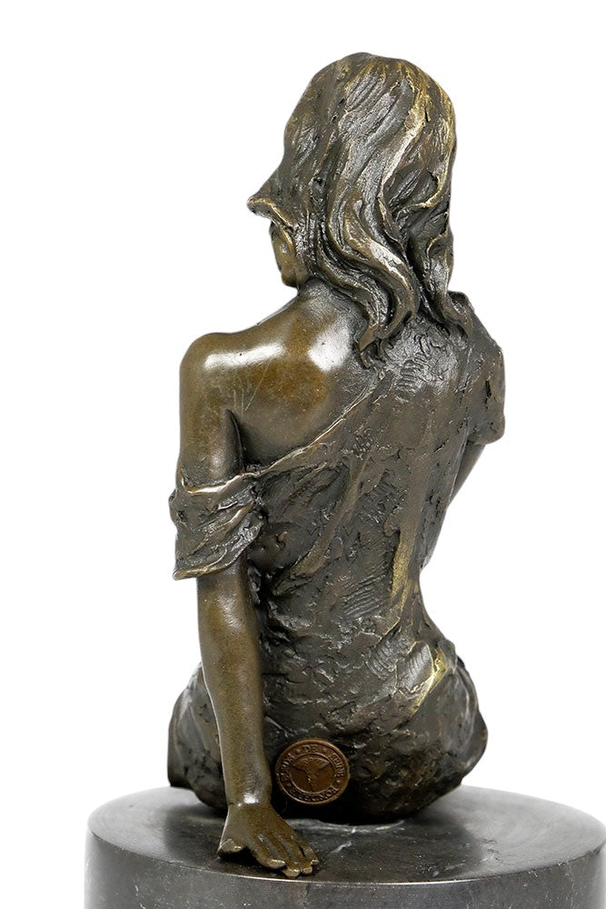 Bronze sculpture of a sitting female in flimsy dress