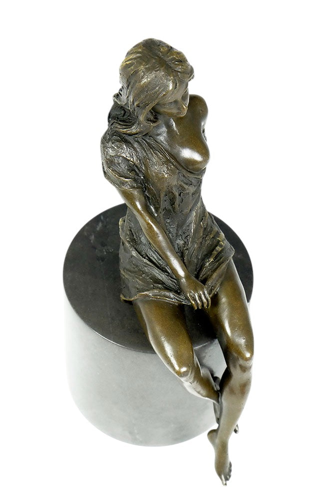 Bronze sculpture of a sitting female in flimsy dress