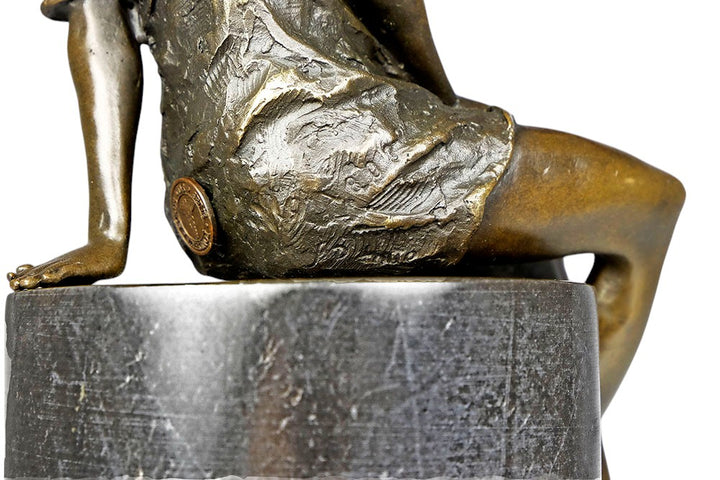 Bronze sculpture of a sitting female in flimsy dress