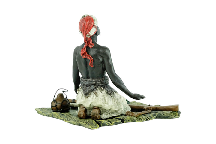Bronze sculpture of an Arabian male on a rug selling weapons