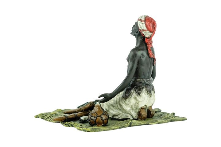 Bronze sculpture of an Arabian male on a rug selling weapons