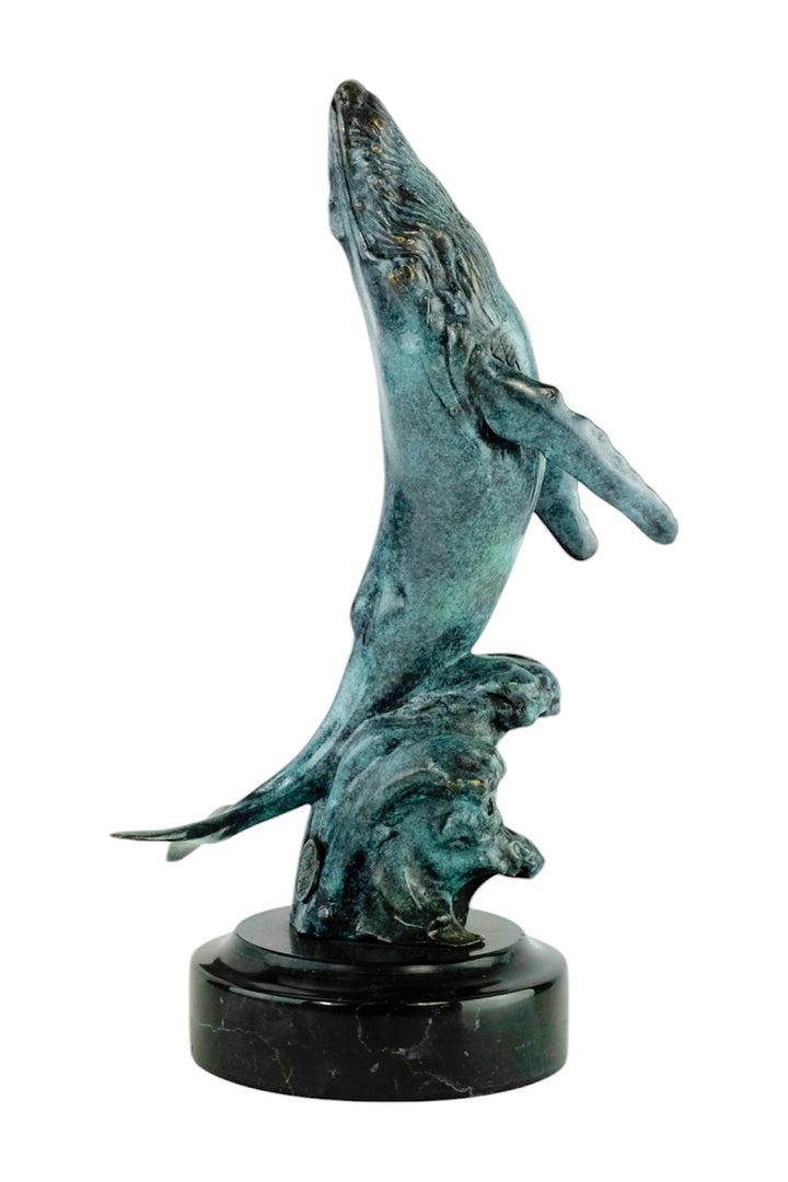 Bronze sculpture of a humpback whale breaching the surface
