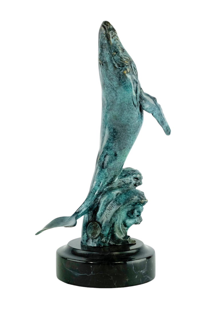 Bronze sculpture of a humpback whale breaching the surface