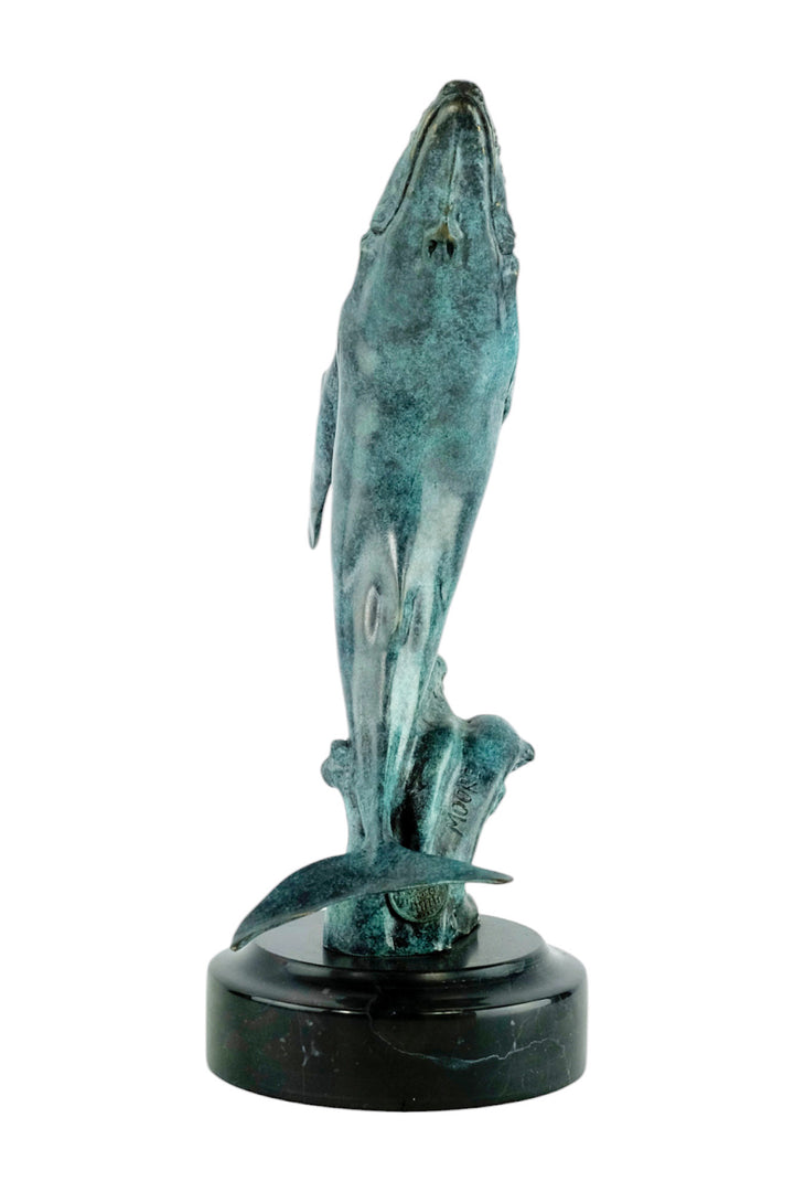 Bronze sculpture of a humpback whale breaching the surface