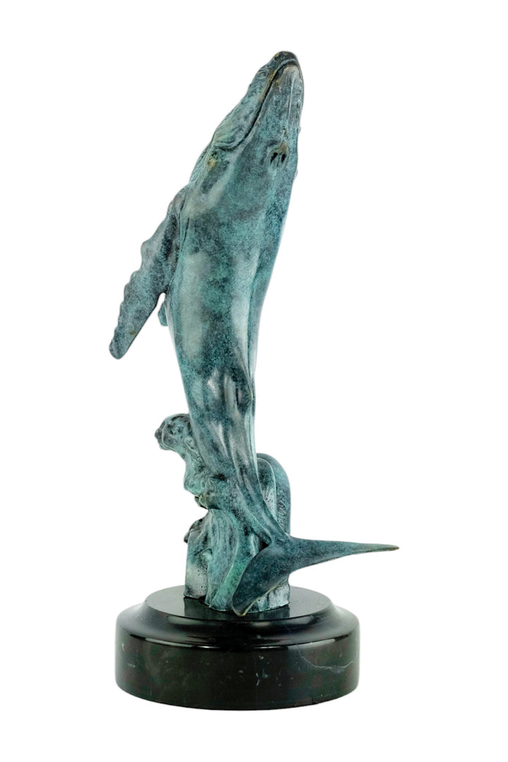 Bronze sculpture of a humpback whale breaching the surface