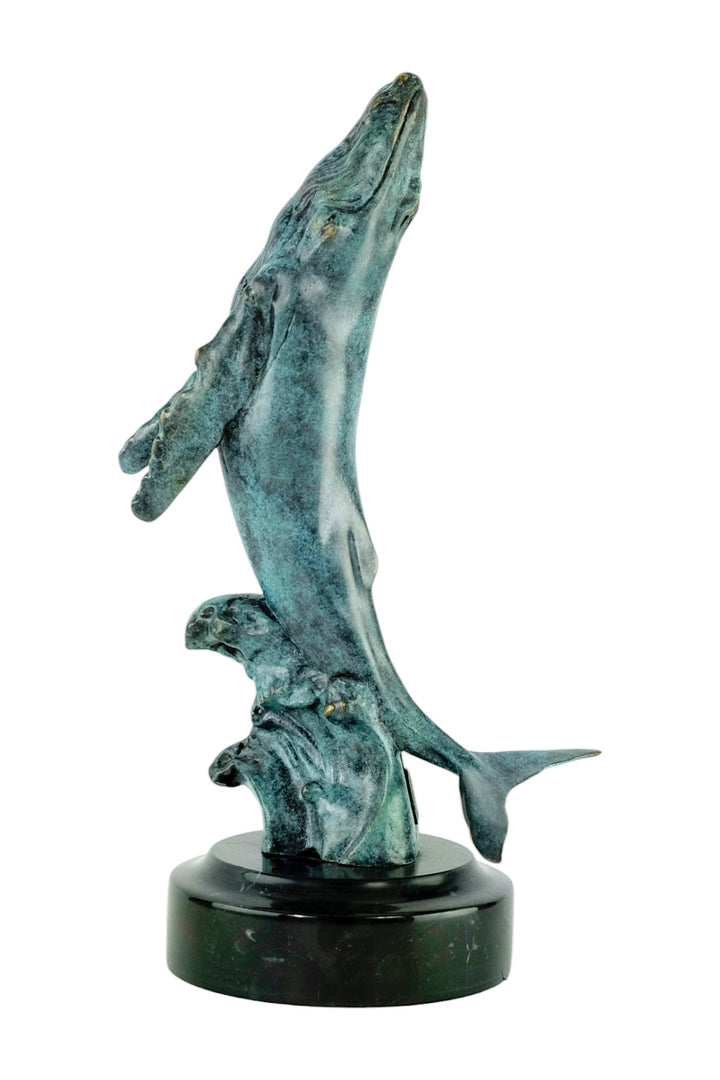 Bronze sculpture of a humpback whale breaching the surface