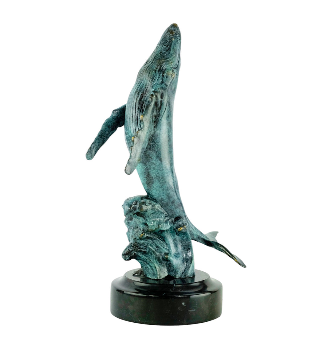 Bronze sculpture of a humpback whale breaching the surface