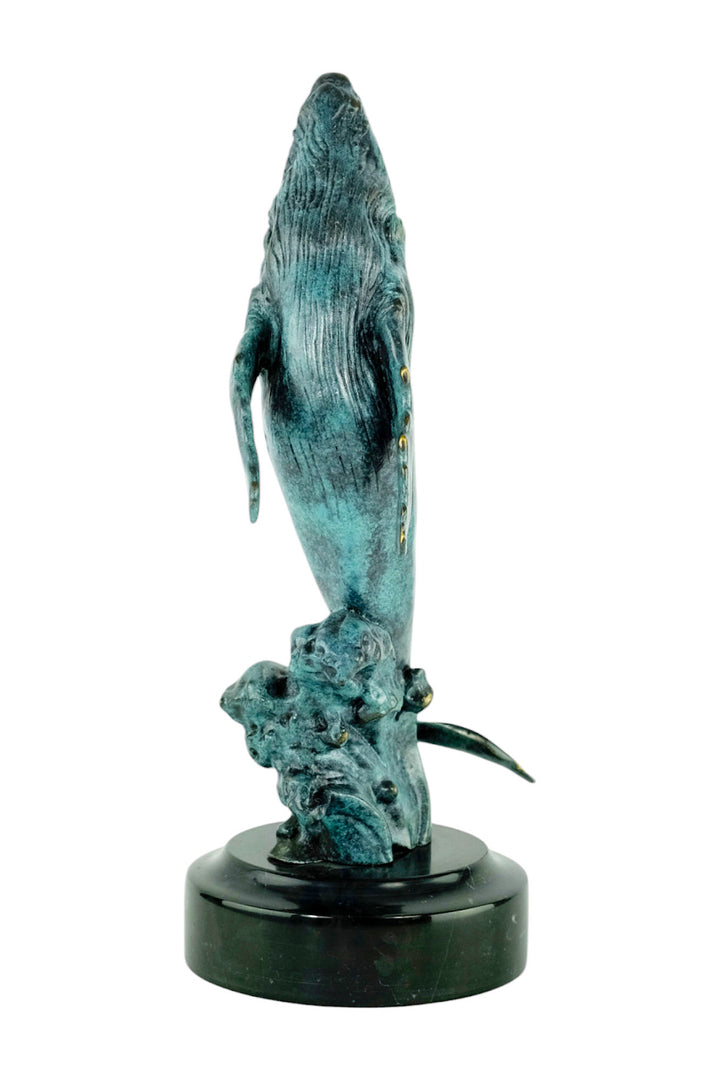 Bronze sculpture of a humpback whale breaching the surface