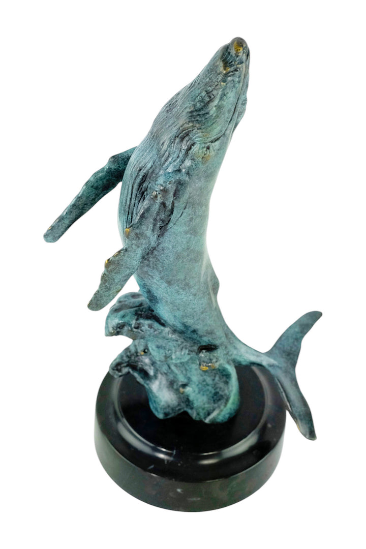 Bronze sculpture of a humpback whale breaching the surface