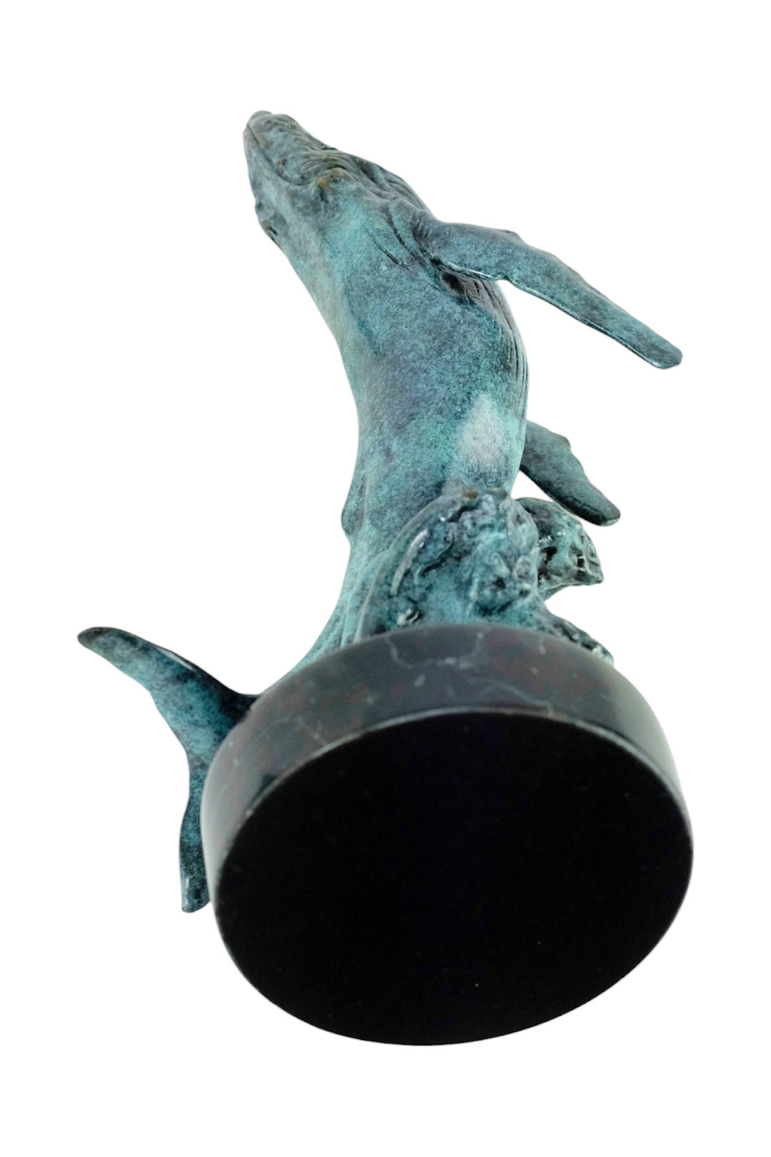 Bronze sculpture of a humpback whale breaching the surface