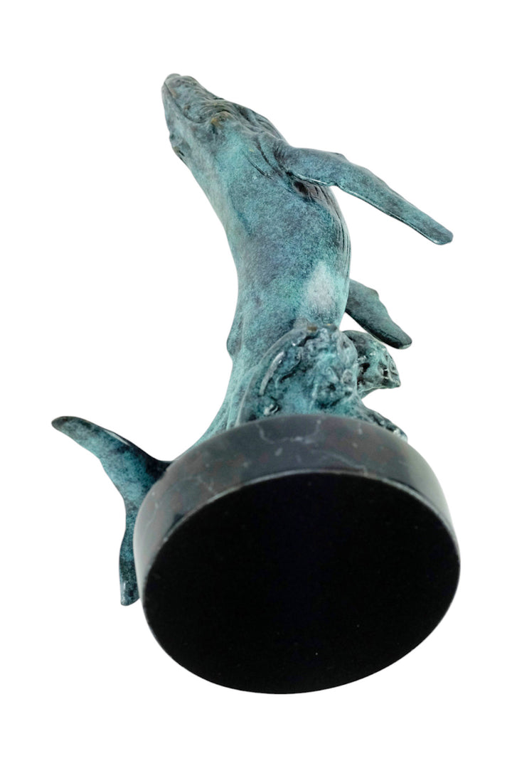 Bronze sculpture of a humpback whale breaching the surface