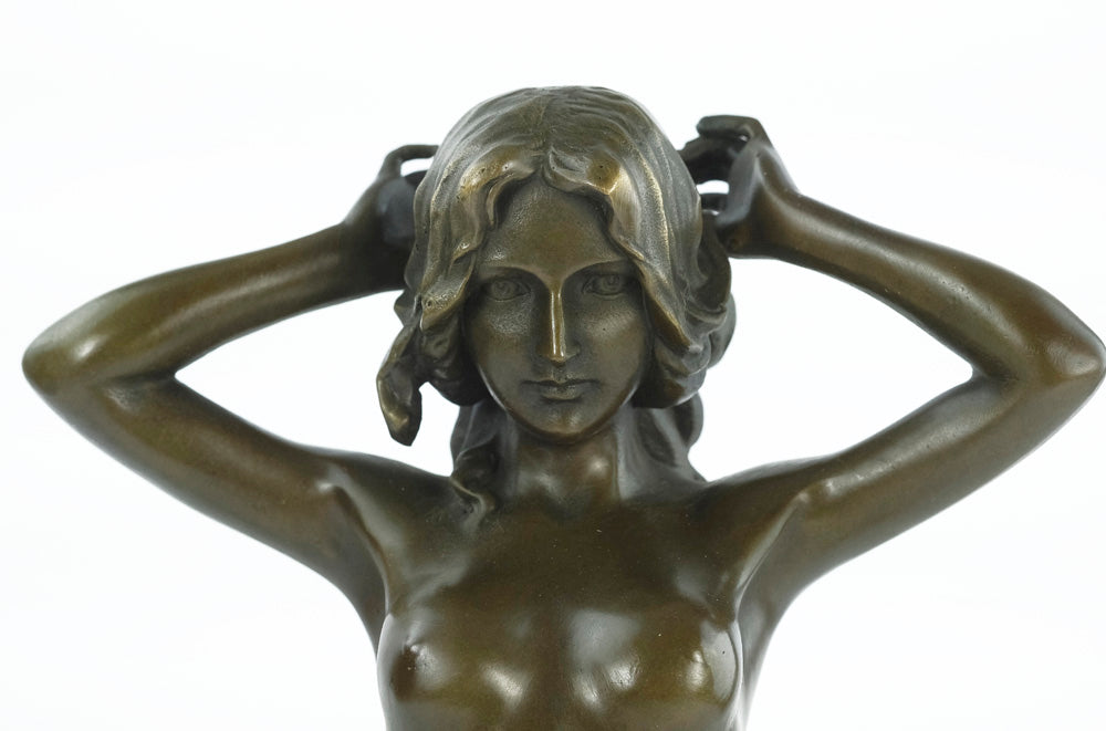 Bronze sculpture of a female nude playing with her hair