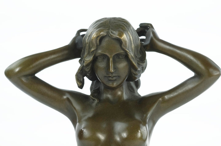 Bronze sculpture of a female nude playing with her hair