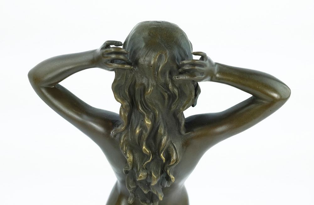 Bronze sculpture of a female nude playing with her hair