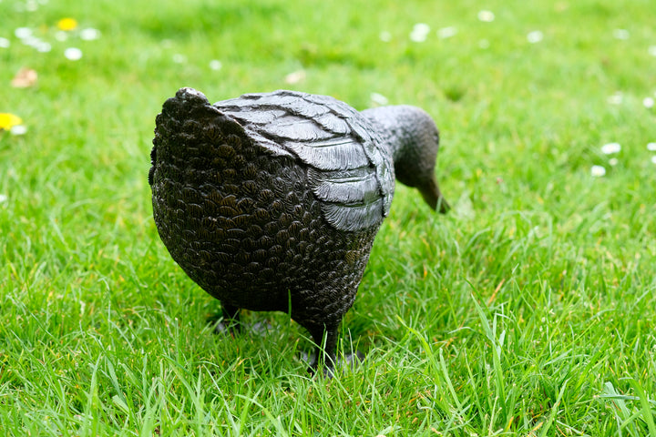 Large bronze sculpture of a foraging duck