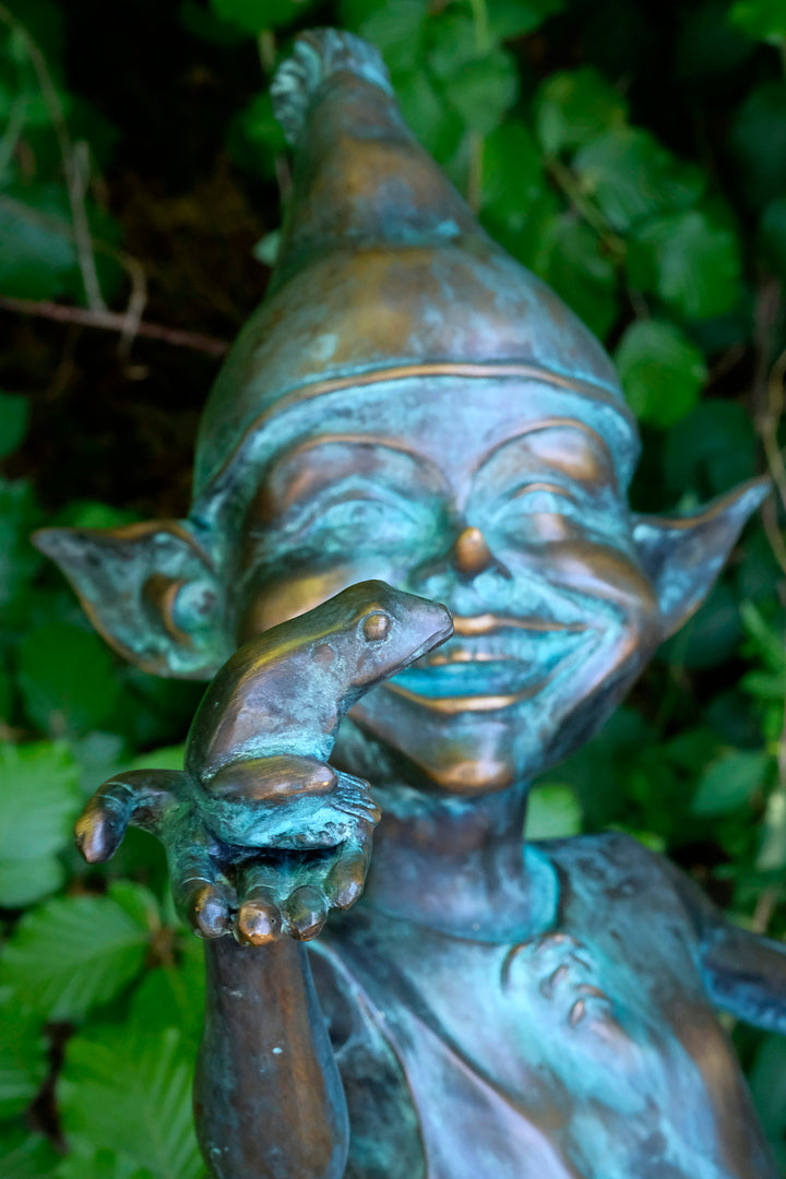 Bronzen sculptuur van een elfje met een kikker zittend in een emmer