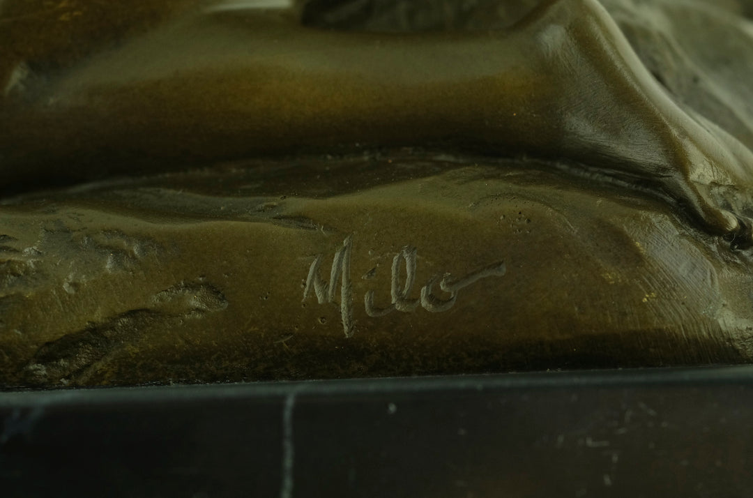 Bronze sculpture of a sensual female nude kneeling on a rock