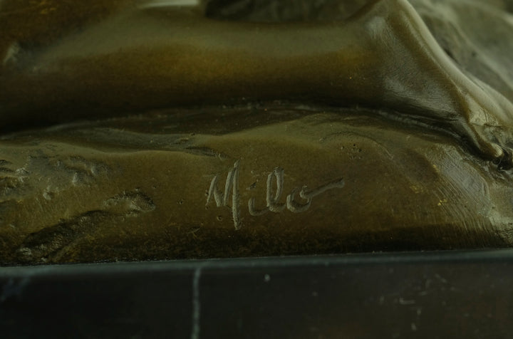 Bronze sculpture of a sensual female nude kneeling on a rock