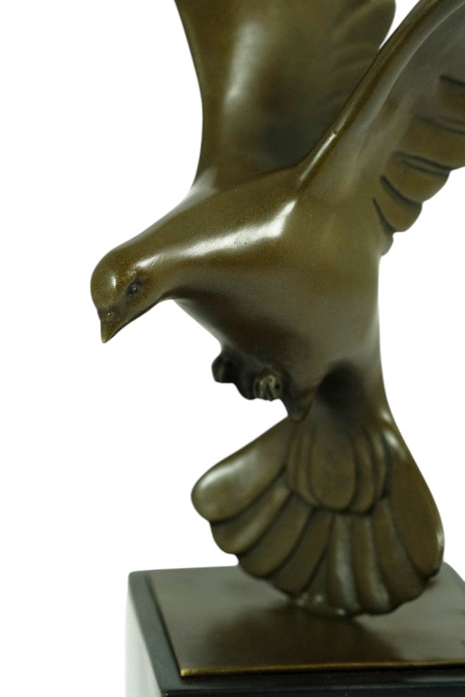 Bronze sculpture of a pigeon descending with wings spread