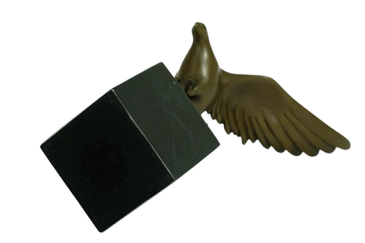 Bronze sculpture of a pigeon descending with wings spread