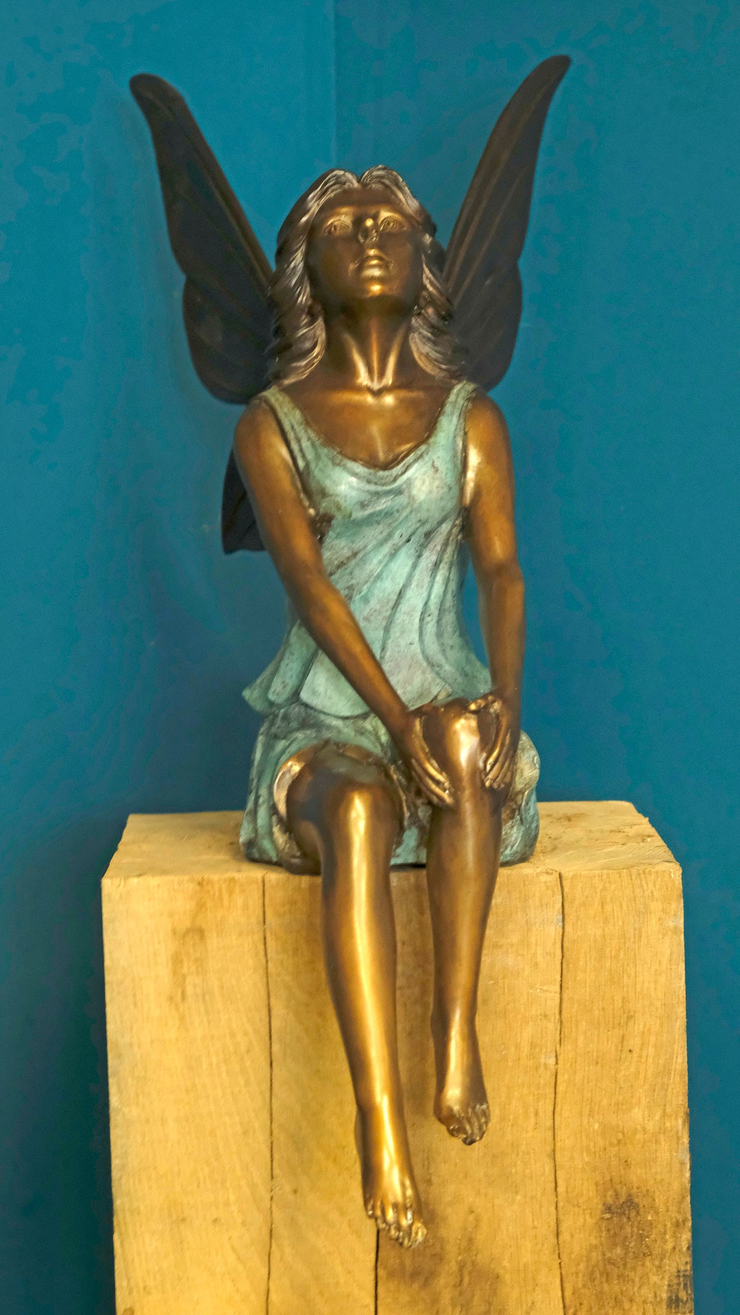 Bronze sculpture of a sitting winged fairy