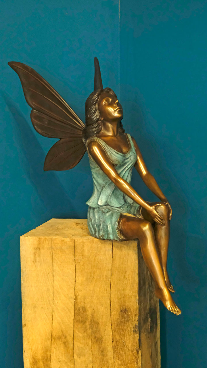 Bronze sculpture of a sitting winged fairy