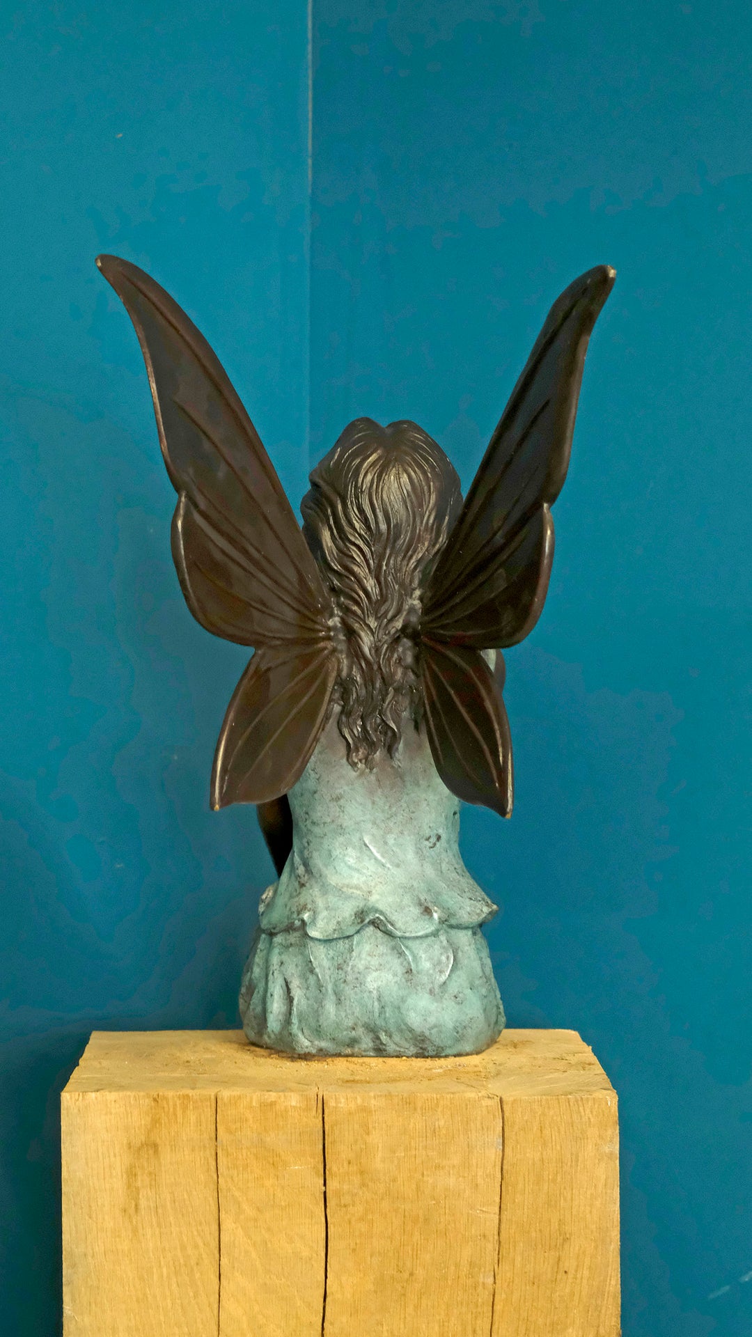 Bronze sculpture of a sitting winged fairy