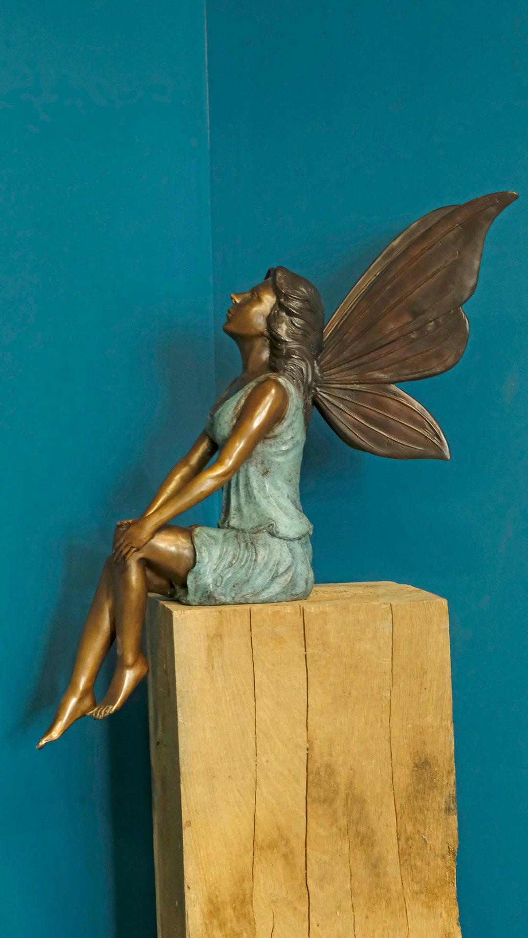Bronze sculpture of a sitting winged fairy