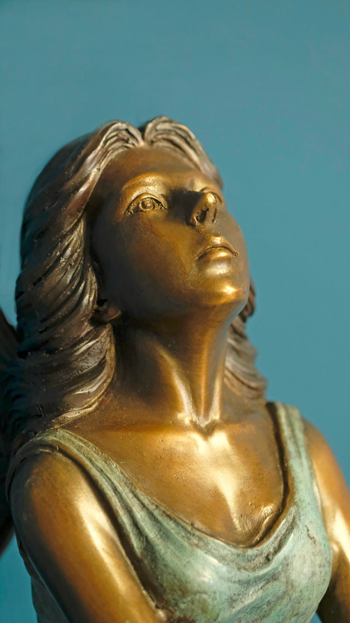 Bronze sculpture of a sitting winged fairy