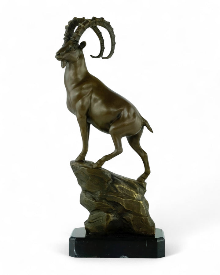 Bronze sculpture of an ibex on a rock