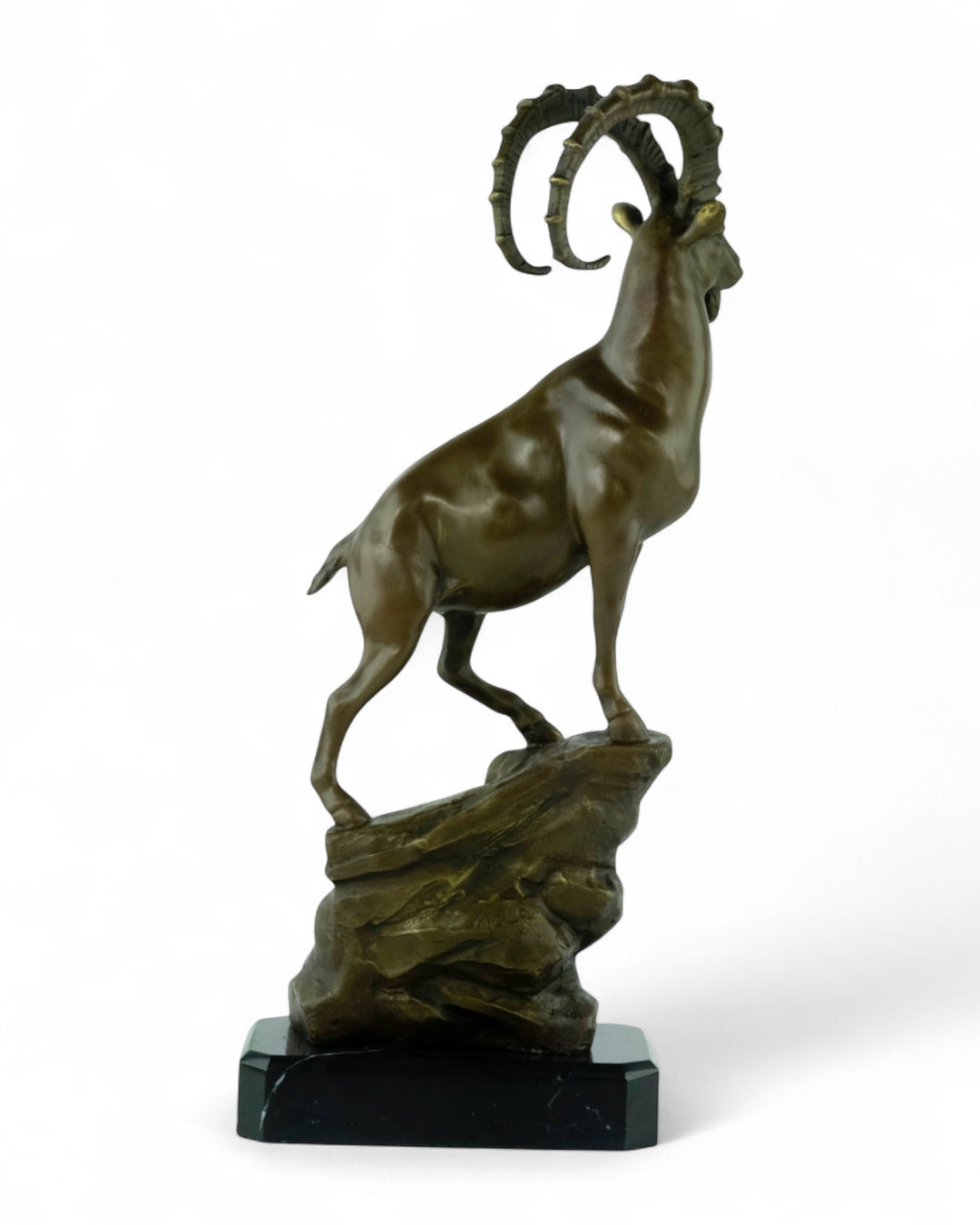 Bronze sculpture of an ibex on a rock