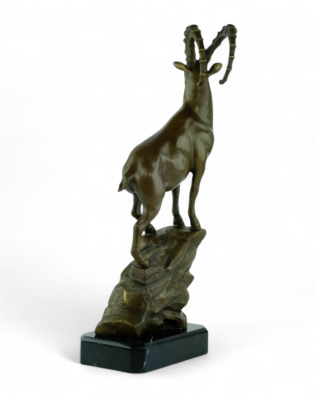 Bronze sculpture of an ibex on a rock