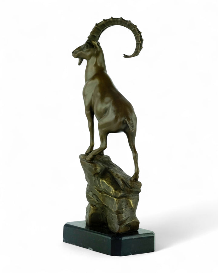 Bronze sculpture of an ibex on a rock