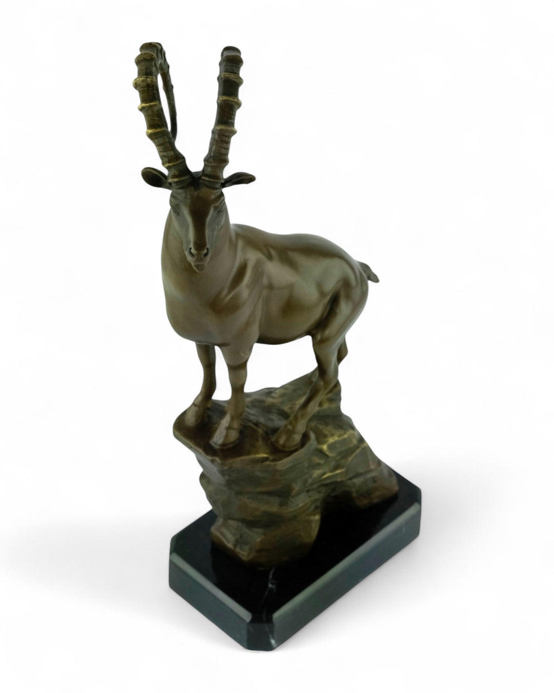 Bronze sculpture of an ibex on a rock