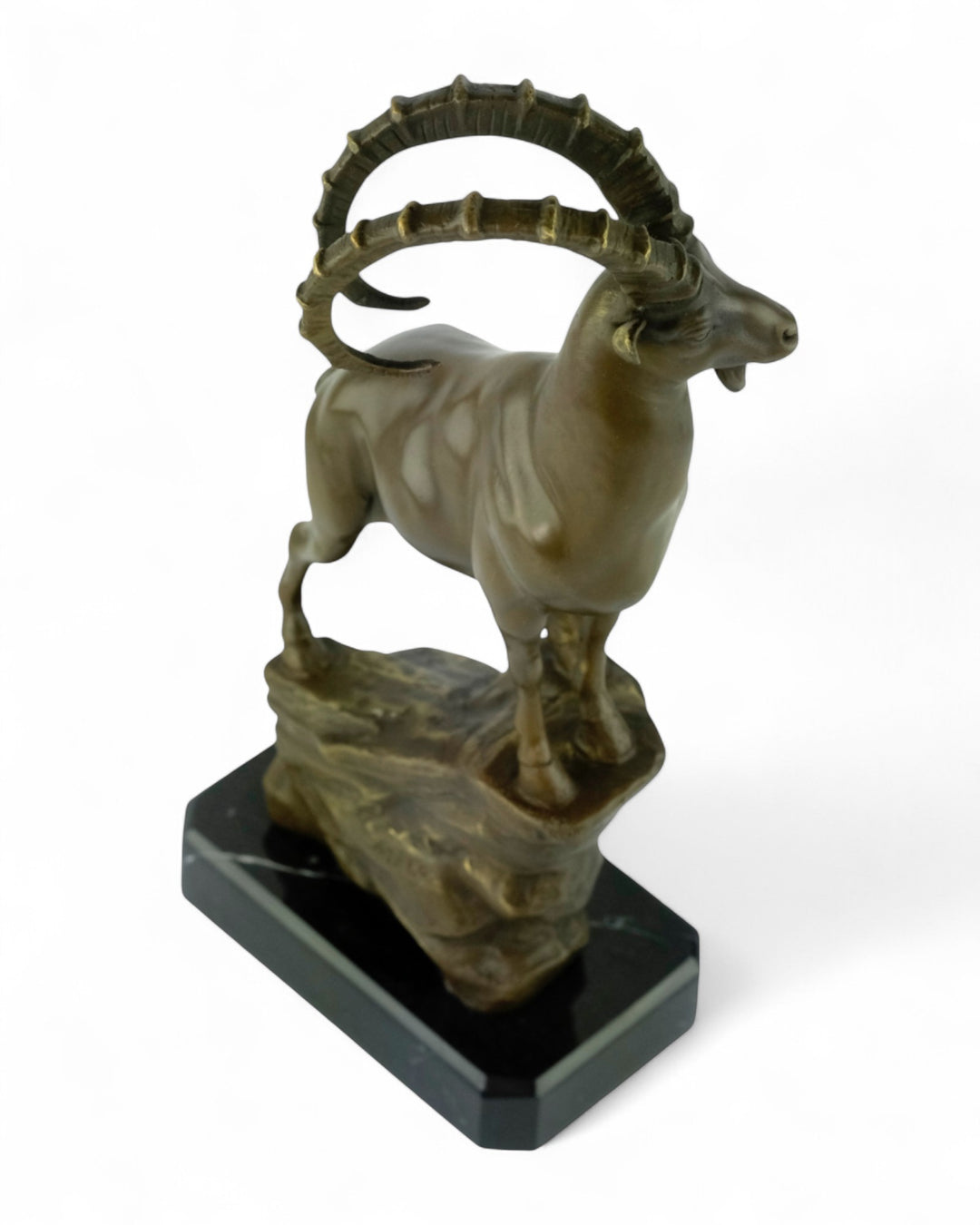 Bronze sculpture of an ibex on a rock